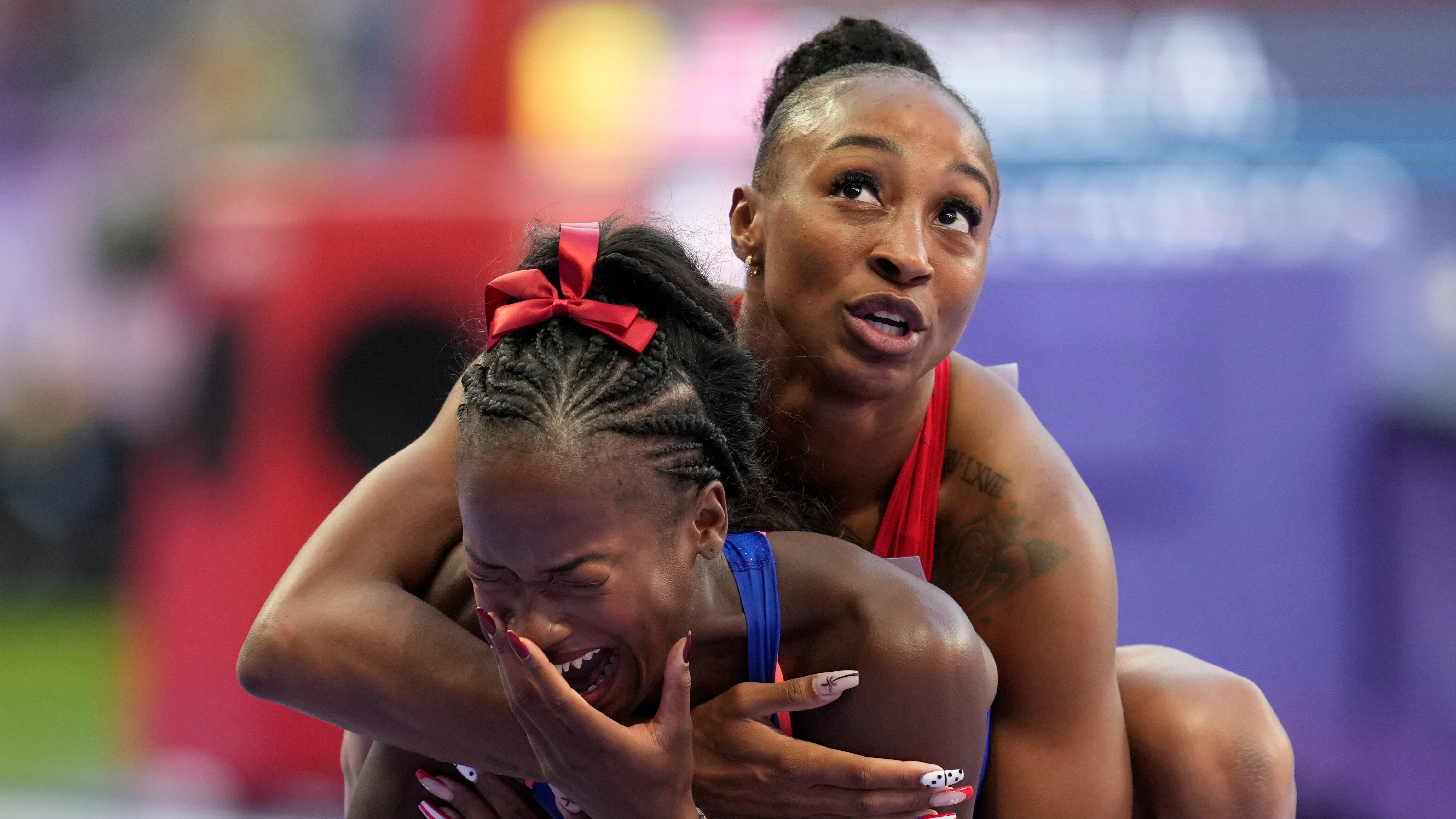 La medallista de bronce Jasmine Camacho-Quinn, de Puerto Rico, abraza a Cyréna Samba-Mayela, de Francia, después de ganar la medalla de plata en la final de los 100 metros con vallas femeninos en los Juegos Olímpicos de Verano de 2024, el sábado 10 de agosto de 2024, en Saint-Denis, Francia. (Foto AP/Ashley Landis)