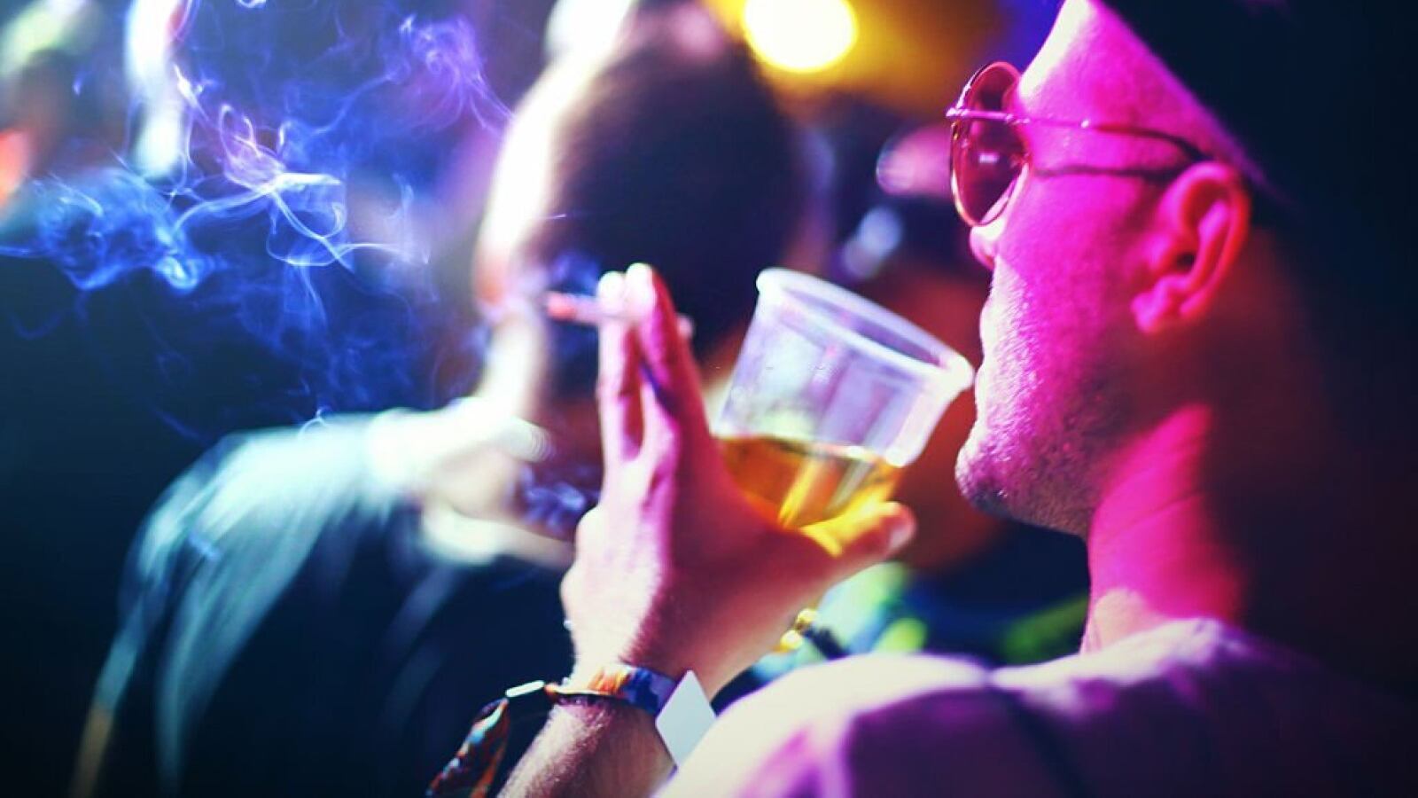 Persona fumando y bebiendo durante una fiesta