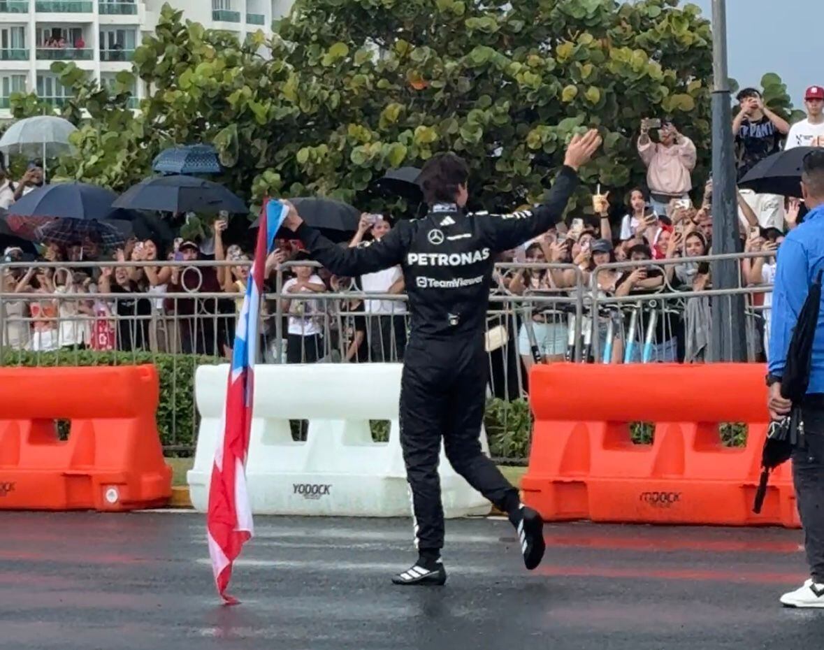 El piloto Esteban Gutiérrez saludando a los fanáticos en el Puente Dos Hermanos, con bandera de Puerto Rico en mano, tras finalizar la primera presentación de un vehículo de motor F1 en Puerto Rico.