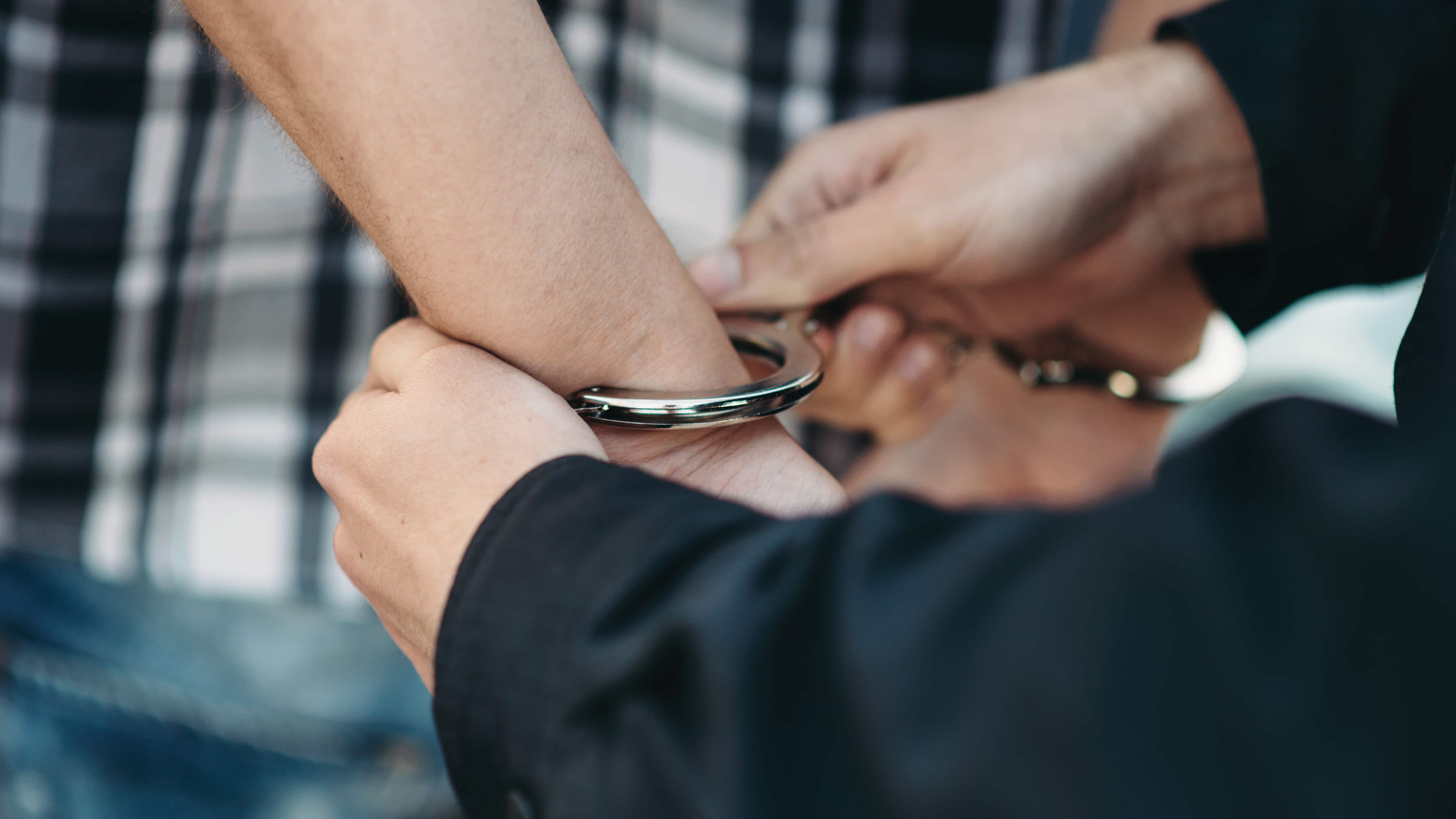 Un policía esposa a un ladrón de coches