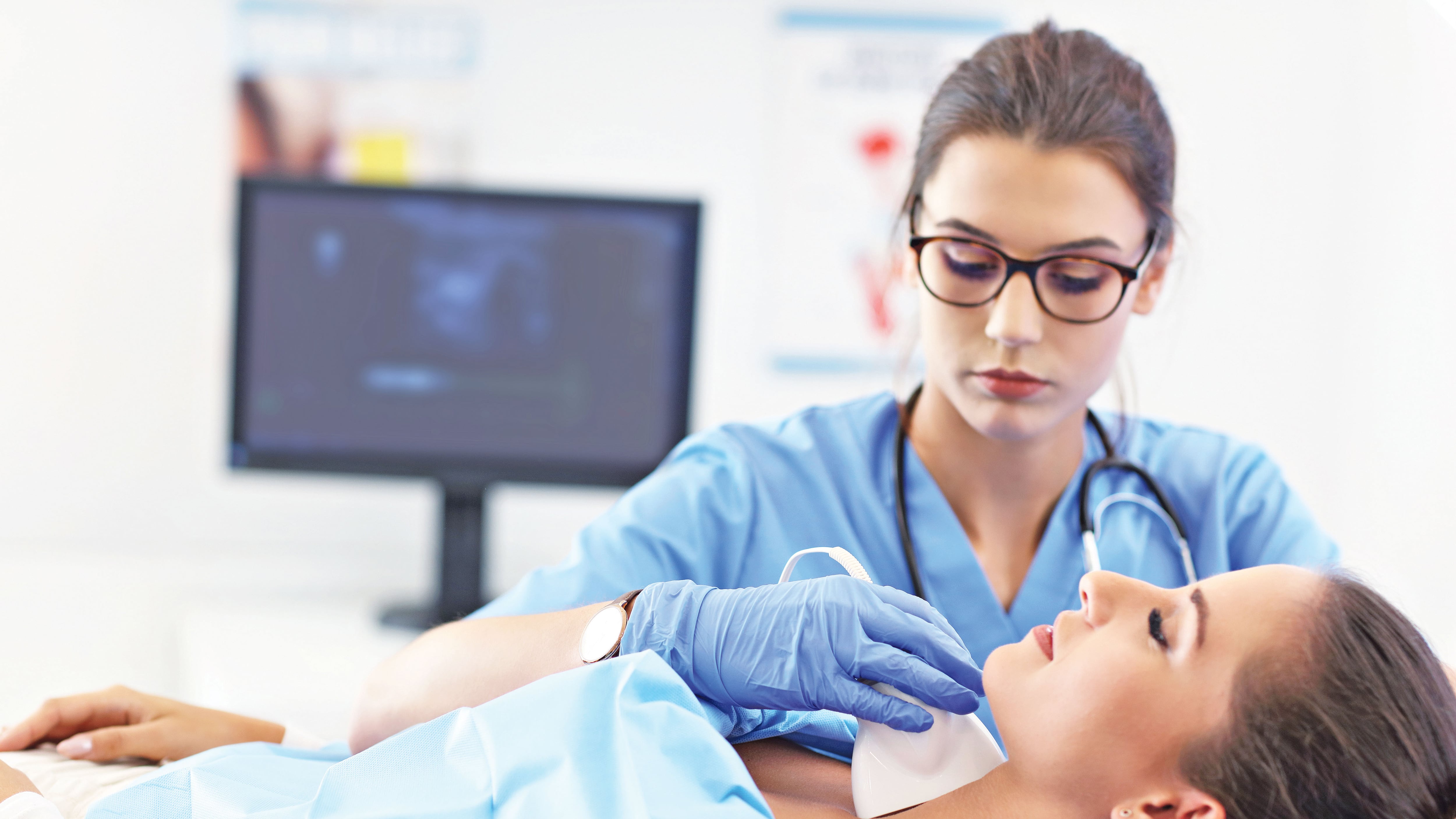 Mujer adulta sometiéndose a una ecografía de tiroides en la consulta de una doctora.