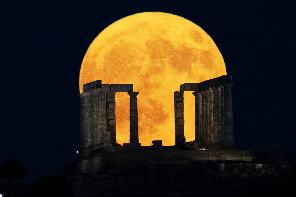 La superluna sale detrás del Templo de Poseidón en el Cabo Sounio, al sur de Atenas, el lunes 19 de agosto de 2024. (Foto AP/Michael Varaklas)