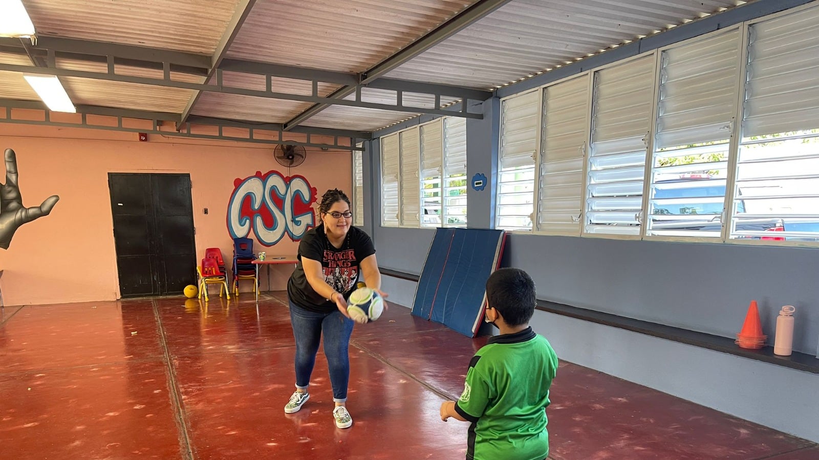 Loraine Cuevas y un estudiante del Colegio San Gabriel juegan con una pelota de fútbol.