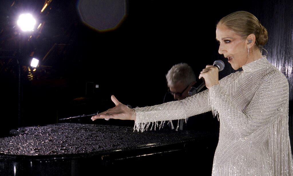 En esta imagen publicada por Olympic Broadcasting Services, la cantante canadiense Celine Dion actuando en la Torre Eiffel.