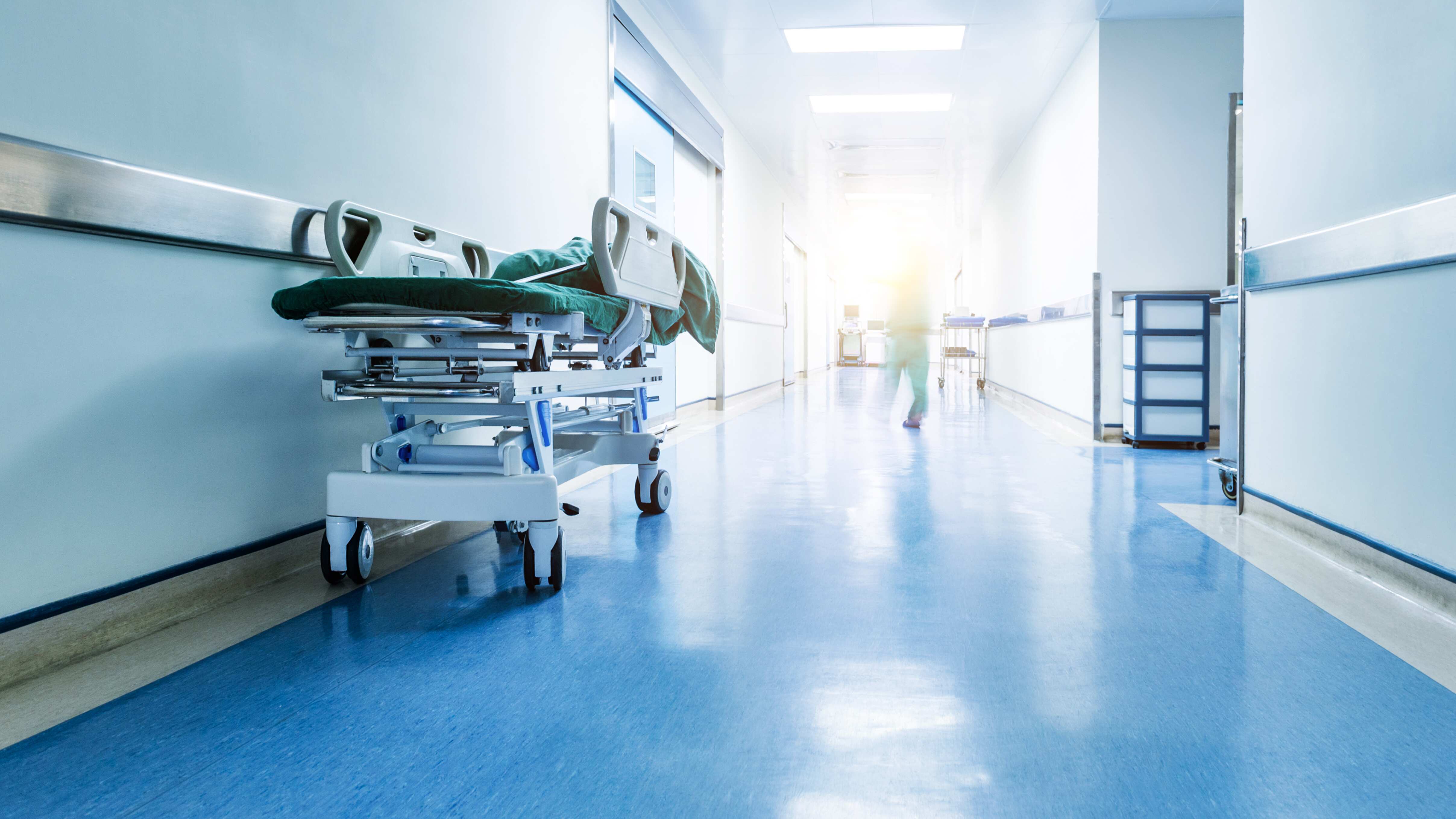 Doctors or nurses walking in hospital hallway, blurred motion.