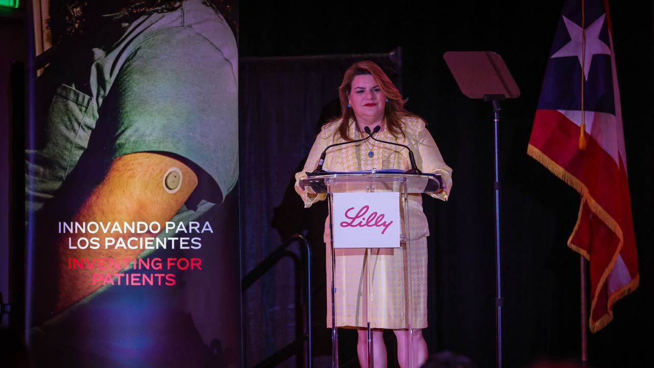 Jenniffer González Colón frente a atril con logo de Eli Lilly