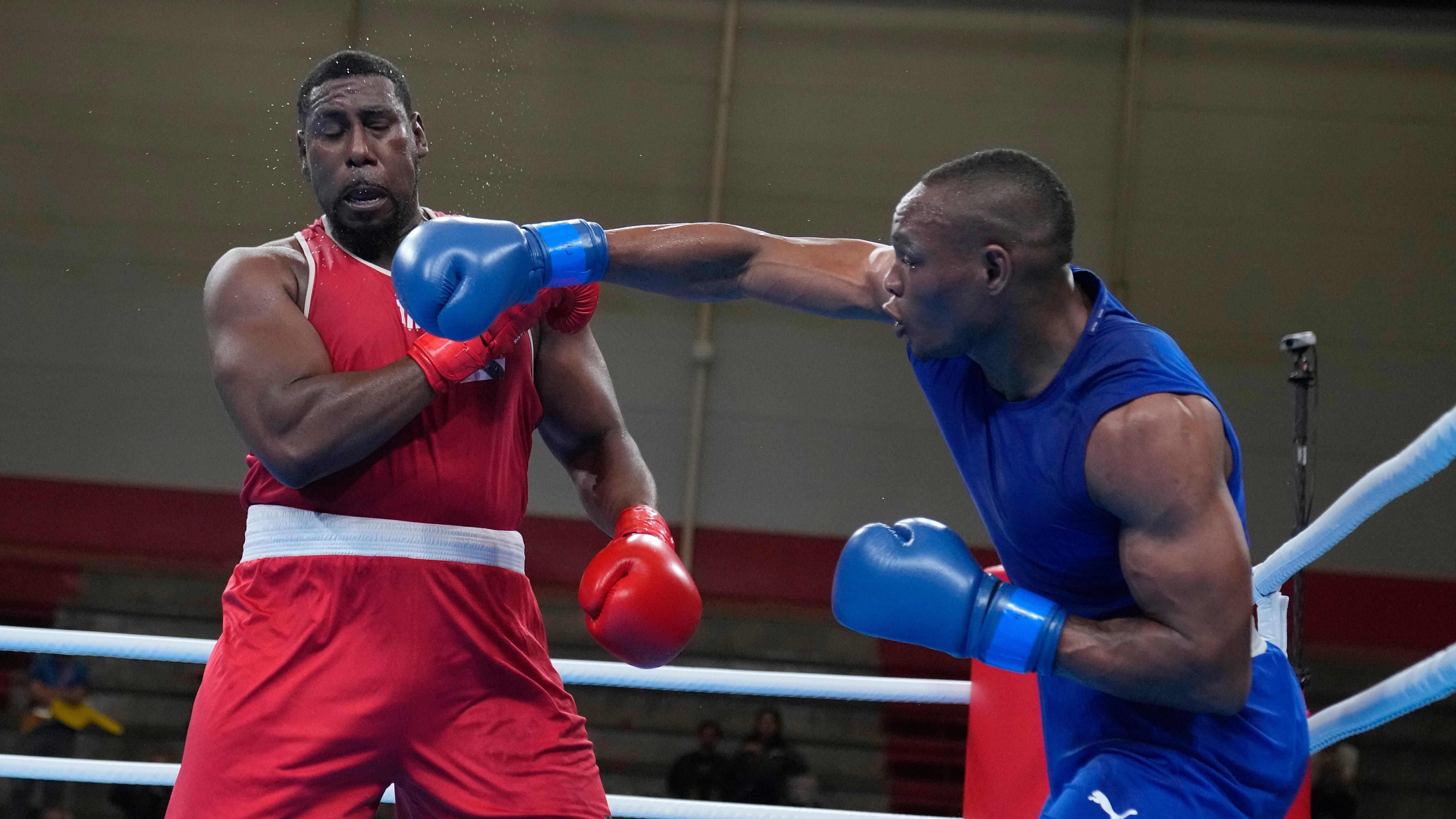 El colombiano Cristian Salcedo lanza un golpe al trinitense Tomas Paul, durante un combate en la categoría de 92 kilogramos en los Juegos Panamericanos de Santiago, el jueves 19 de octubre de 2023 (AP Foto/Martín Mejía)