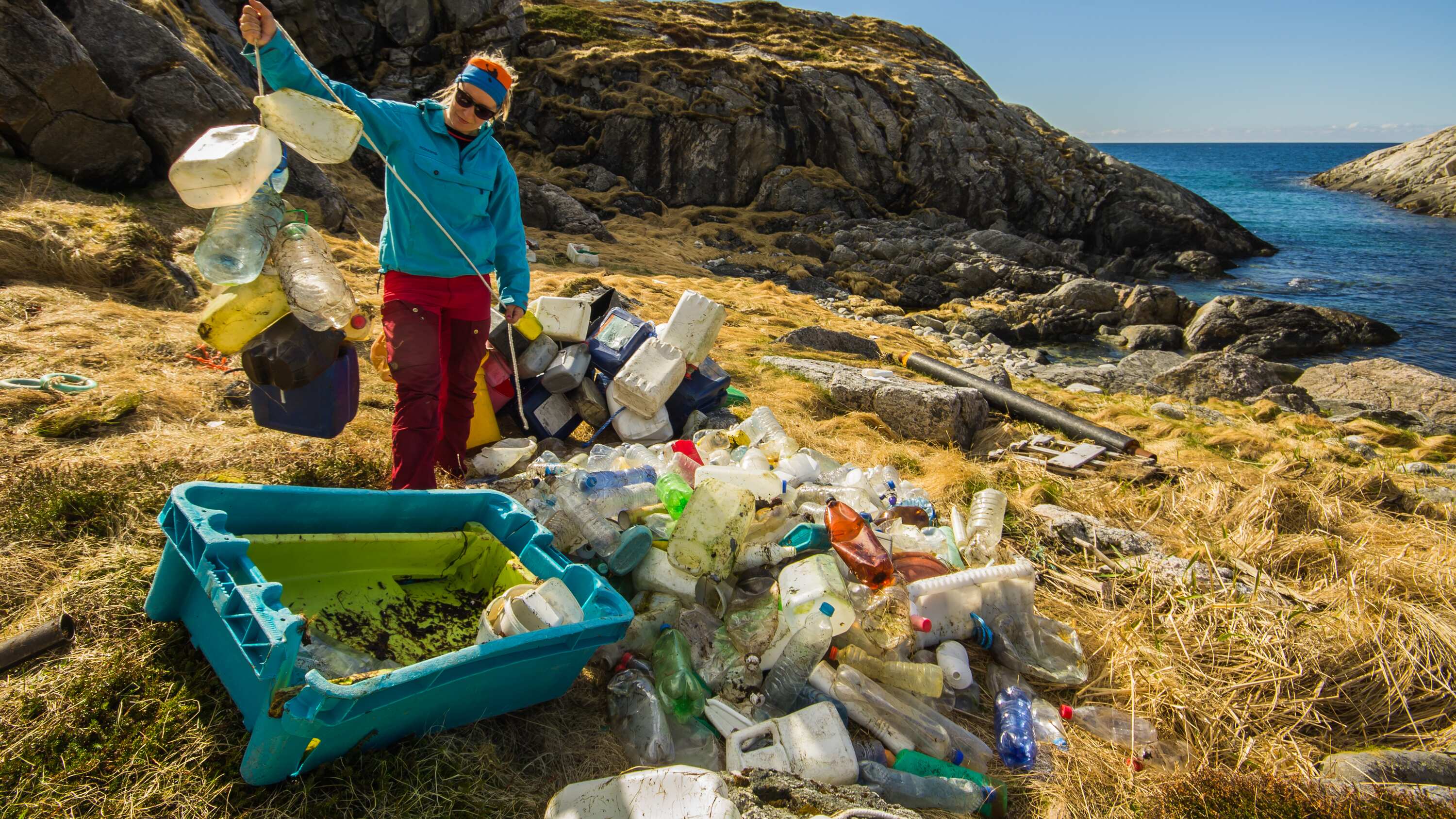 Mujer cerca de la orilla del mar recoge envases plásticos