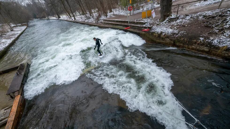Un hombre prueba la ola temporal de Eisbach en el Jardín Inglés de Múnich, Alemania, el 26 de diciembre de 2025. (Peter Kneffel/dpa vía AP)