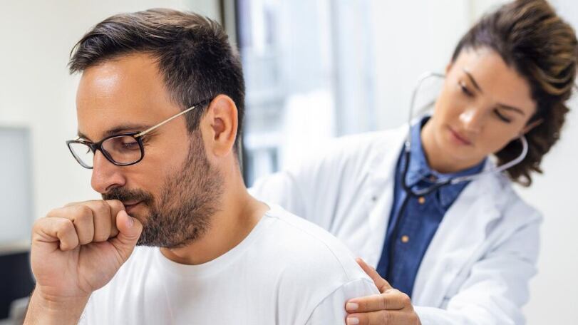 Una doctora en la clínica realiza la auscultación de los pulmones de un paciente con síntomas de coronavirus o neumonía