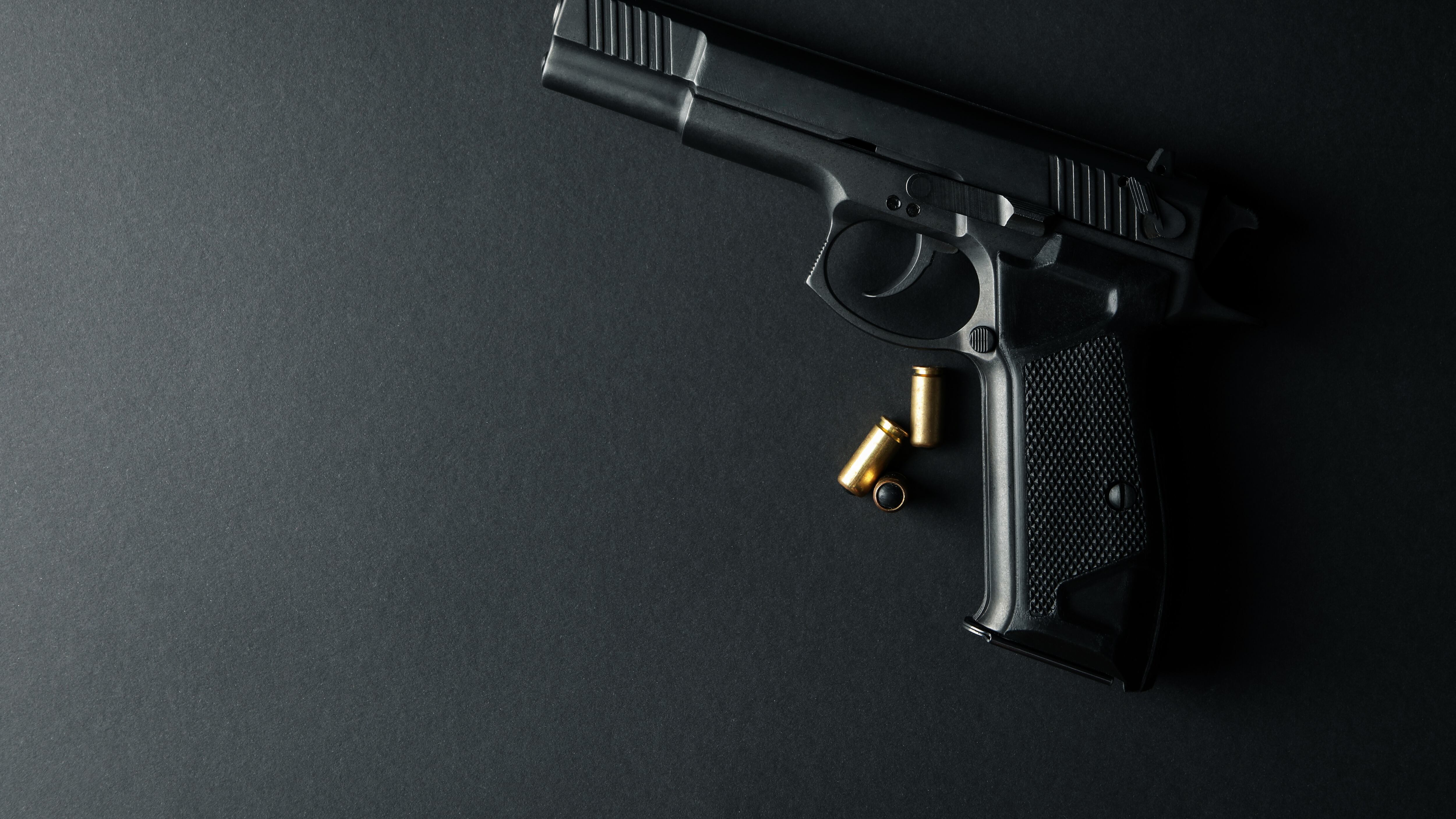 Pistola y balas traumáticas sobre fondo negro. Arma de defensa personal