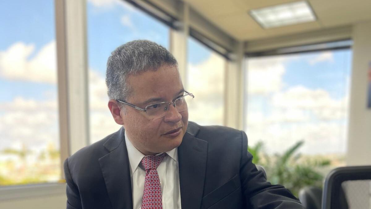 Víctor Ramos Otero con mano postrada sobre mesa.