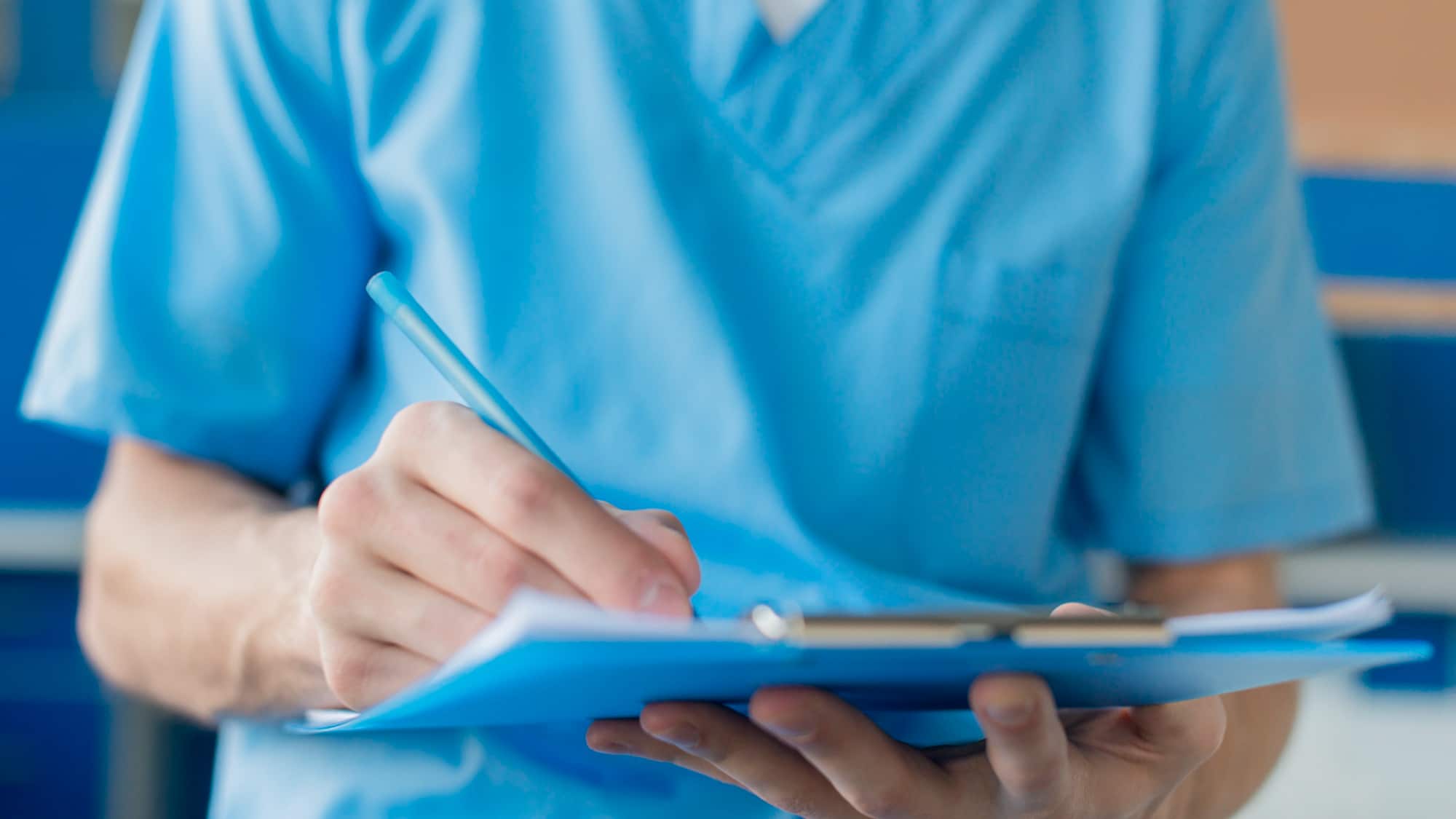 Enfermero apunta en tablero.