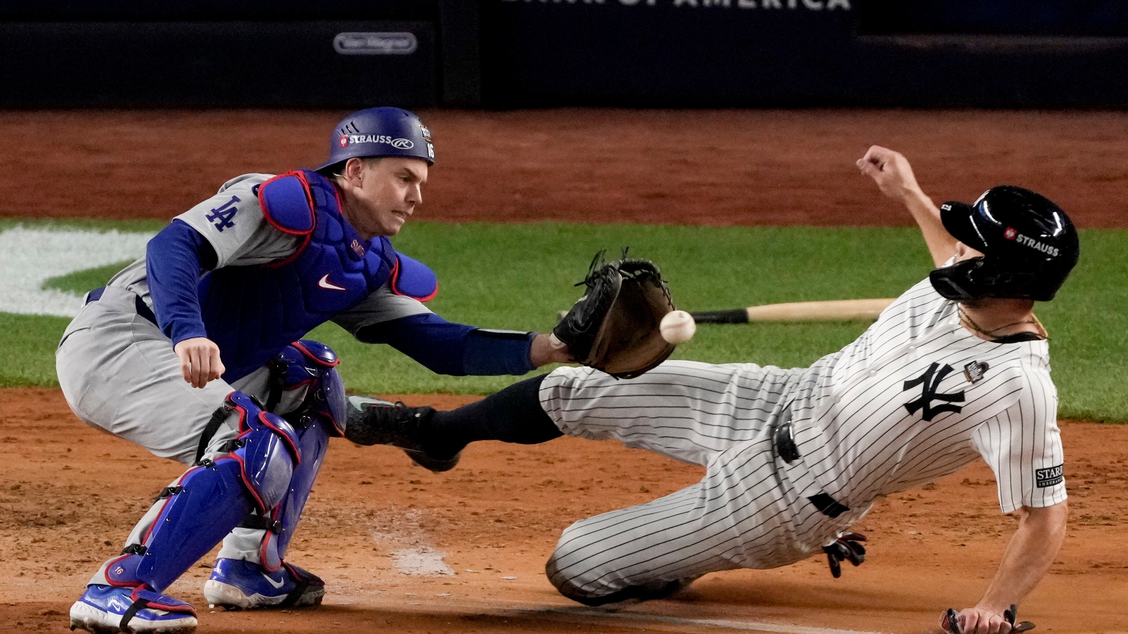 Giancarlo Stanton, de los Yankees de Nueva York, es puesto out en el plato por el receptor de los Dodgers de Los Ángeles, Will Smith, durante la cuarta entrada del tercer juego de la Serie Mundial de béisbol, el lunes 28 de octubre de 2024, en Nueva York. (Foto AP/Frank Franklin II)
