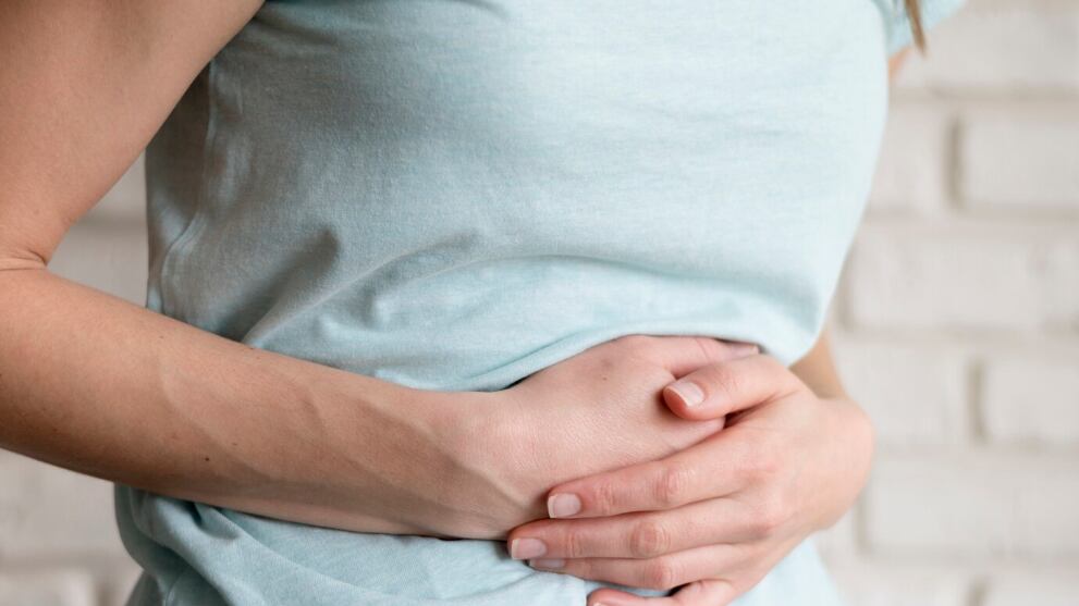 Mujer que tiene calambres en el interior.