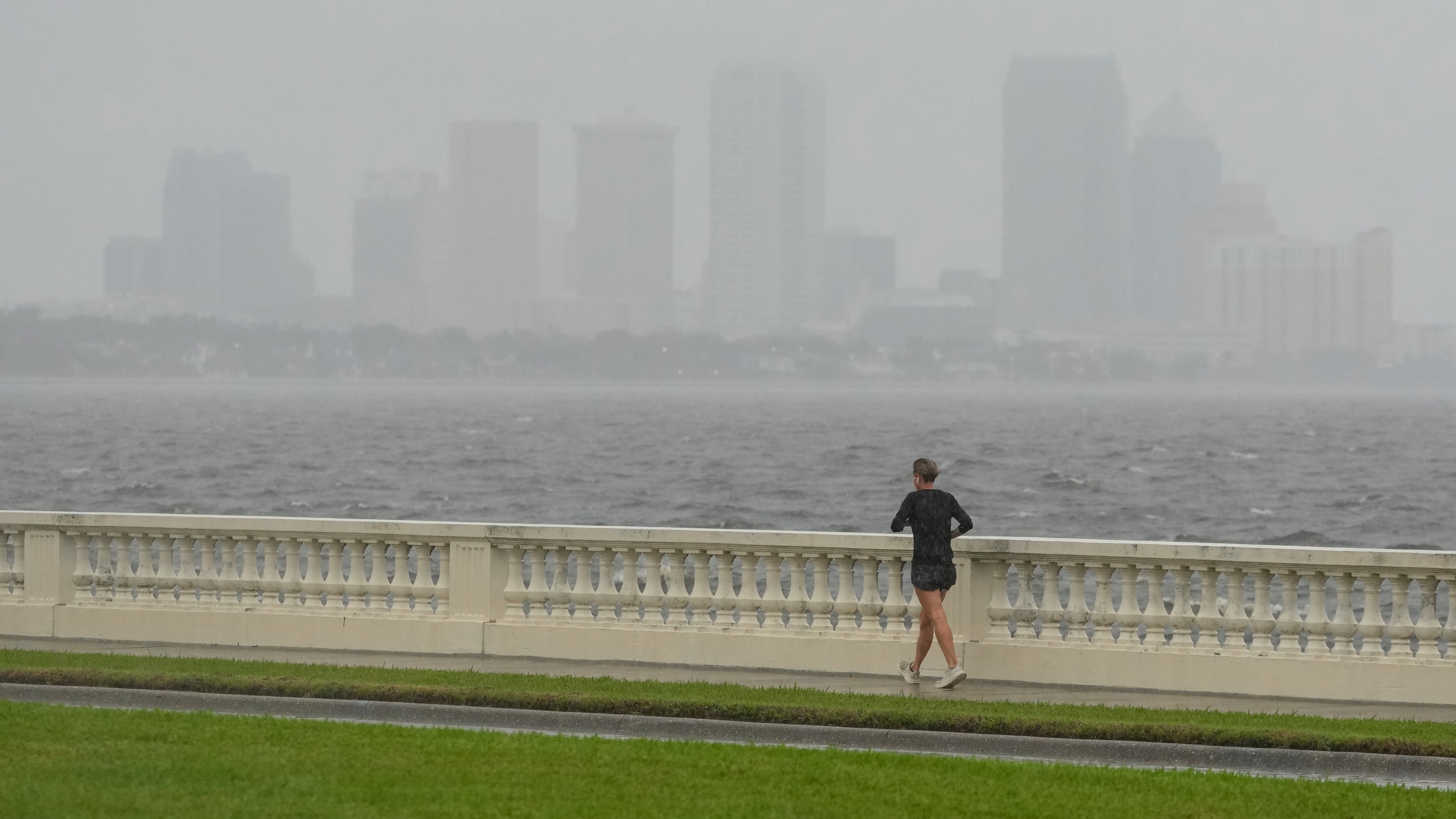 Una mujer corre en medio de una lluvia ligera previo a la llegada del huracán Milton, el miércoles 9 de octubre de 2024, en Tampa, Florida. (AP Foto/Julio Cortez)