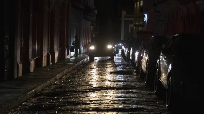 Los faros de un auto iluminan las calles empedradas del Viejo San Juan, Puerto Rico, durante un apagón en la isla, el 16 de abril de 2025. (AP Foto/Alejandro Granadillo)