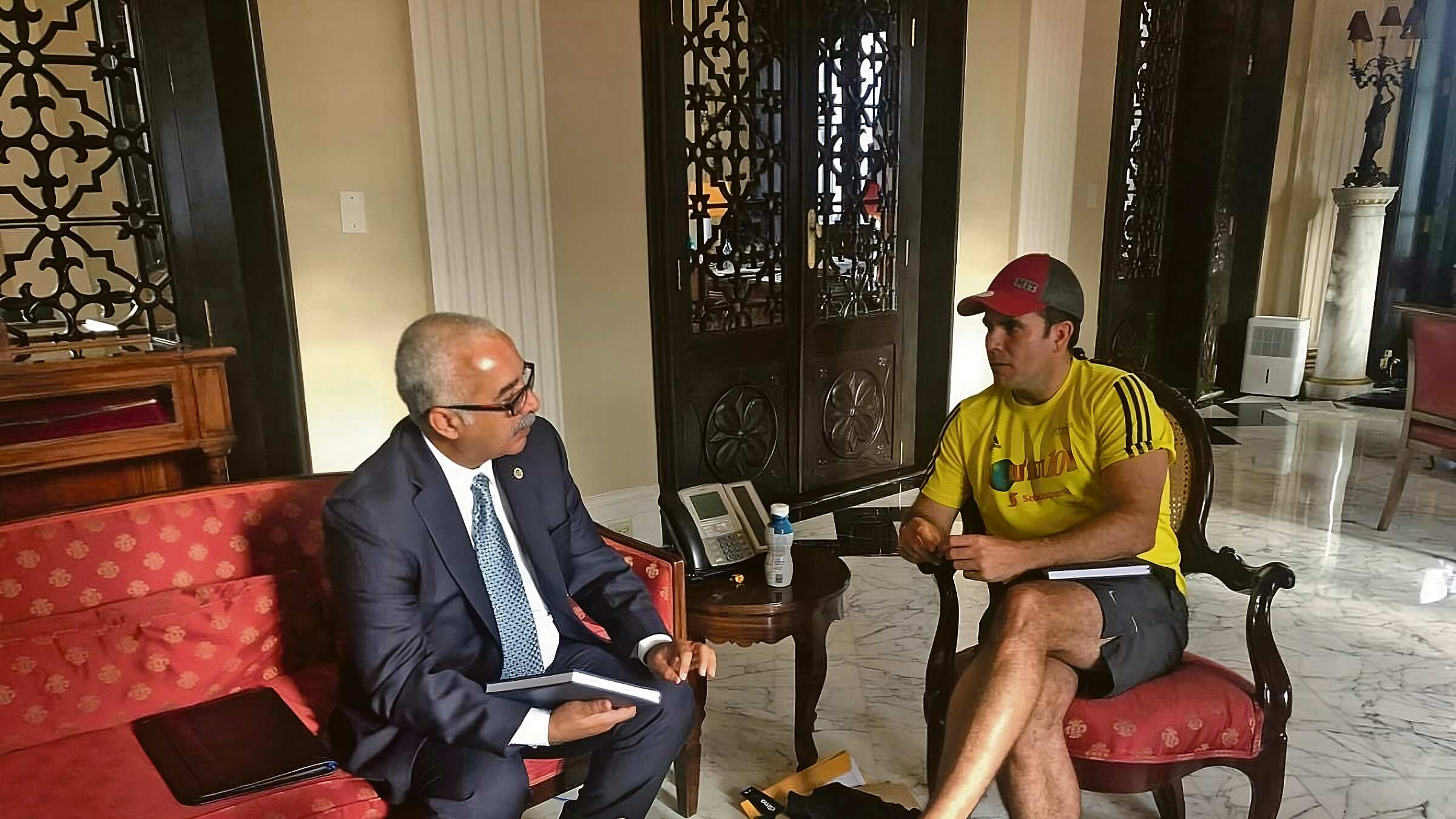 En lo que parece ser La Fortaleza, Raúl Maldonado aparece en traje, sentado al lado de Rosselló, quien lleva puesta ropa de ejercicio.