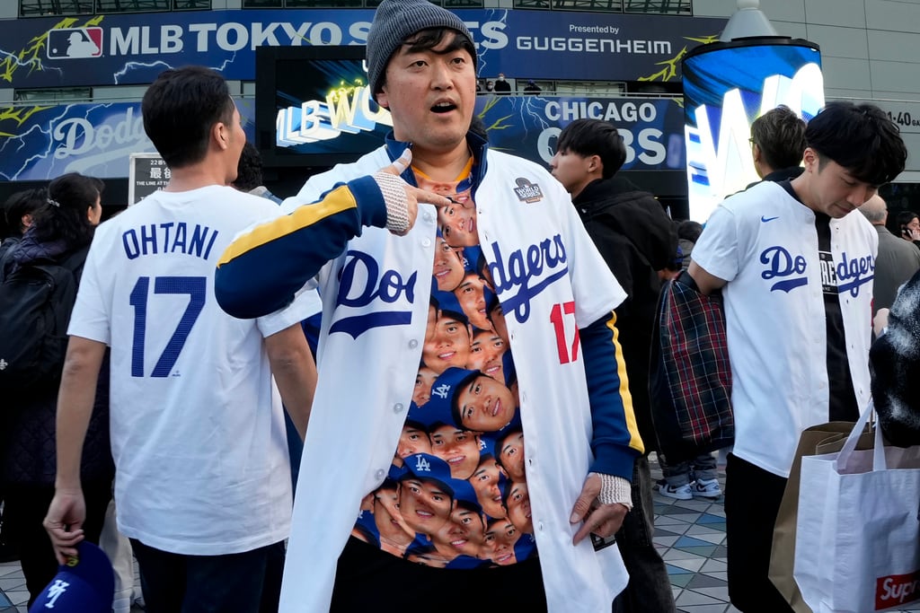 Un aficionado muestra una camiseta de Shohei Ohtani, de los Dodgers de Los Ángeles, antes de un partido de la Serie Mundial de Béisbol entre los Dodgers de Los Ángeles y los Cachorros de Chicago en el Tokyo Dome, Tokio, el martes 18 de marzo de 2025. (Foto AP/Shuji Kajiyama)