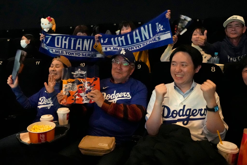 La gente espera antes de una proyección pública de un partido de béisbol de la Serie Mundial de Béisbol entre los Dodgers de Los Ángeles y los Cachorros de Chicago en el Tokyo Dome, Tokio, el martes 18 de marzo de 2025. (Foto AP/Shuji Kajiyama)