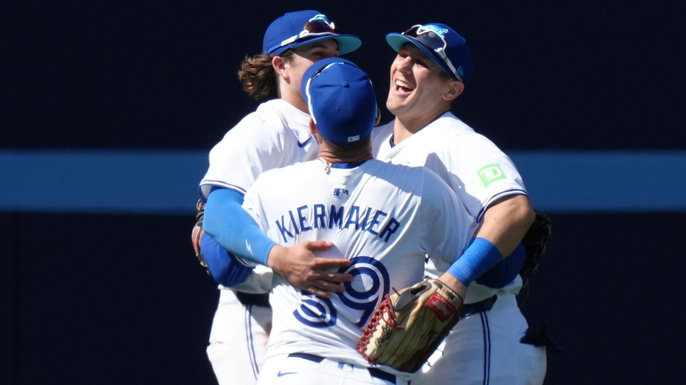 Los jardineros de los Azulejos de Toronto, Daulton Varsho, derecha, Kevin Kiermaier, centro y Addison Barger, izquierda, celebran después de conseguir la victoria sobre los Guardianes de Cleveland en el juego de béisbol en Toronto, el domingo 16 de junio de 2024. (Chris Young/The Canadian Press vía AP)