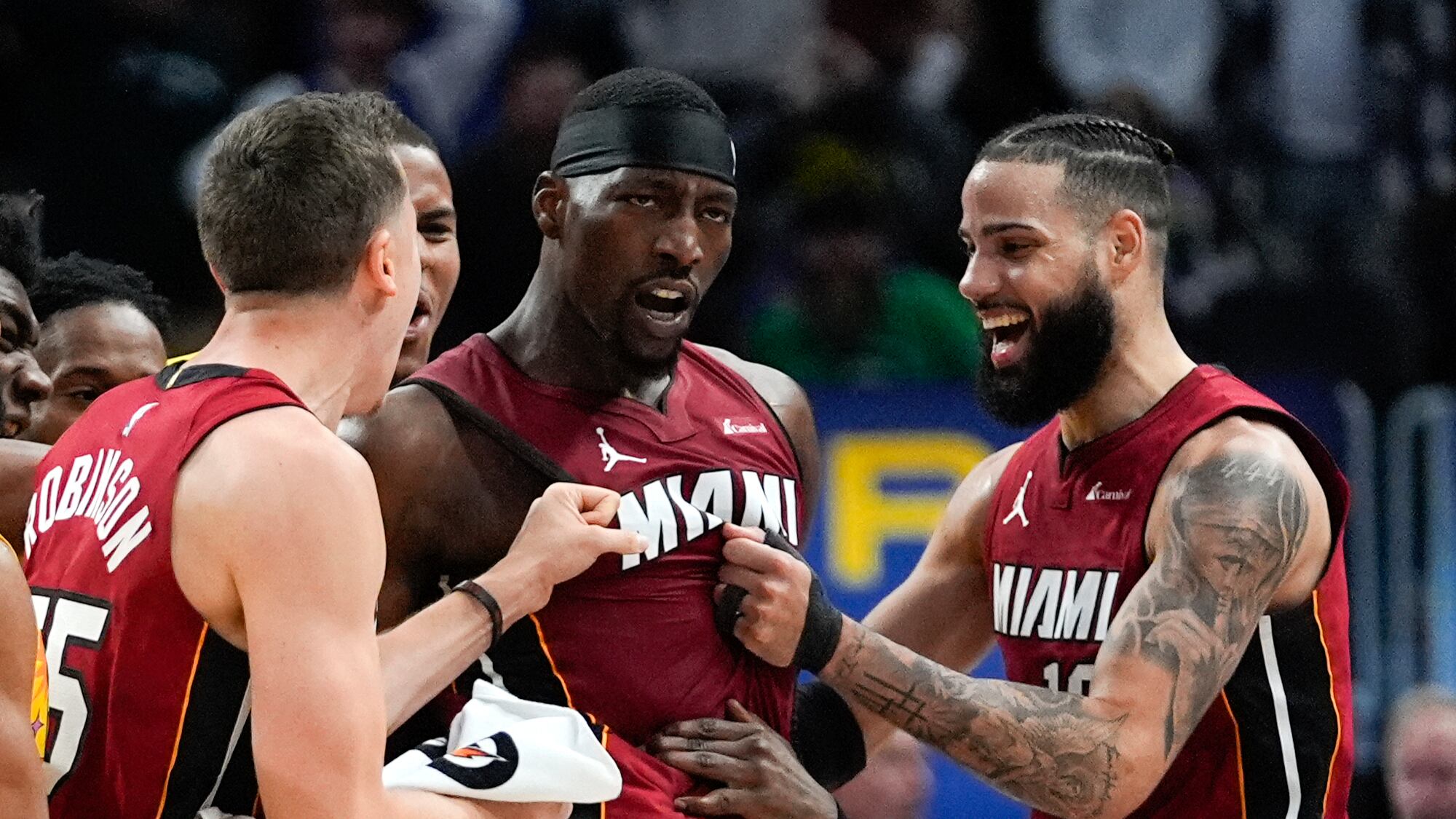 El centro del Heat de Miami, Bam Adebayo celebra su lanzamiento ganador junto a Duncan Robinson (izquierda), y Caleb Martin (derecha) en la segunda mitad del juego de baloncesto de la NBA ante los Pistons de Detroit, en Detroit, el domingo 17 de marzo de 2024. (AP Foto/Paul Sancya)