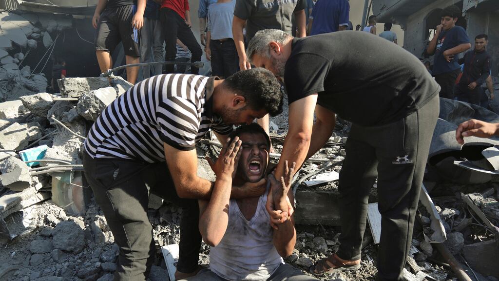 Dos palestinos consuelan a un hombre que llora tras perder familiares bajo los escombros, de una casa destruida tras un ataque aéreo israelí en Ciudad de Gaza, el sábado 4 de noviembre de 2023. (AP Foto/Abed Khaled)