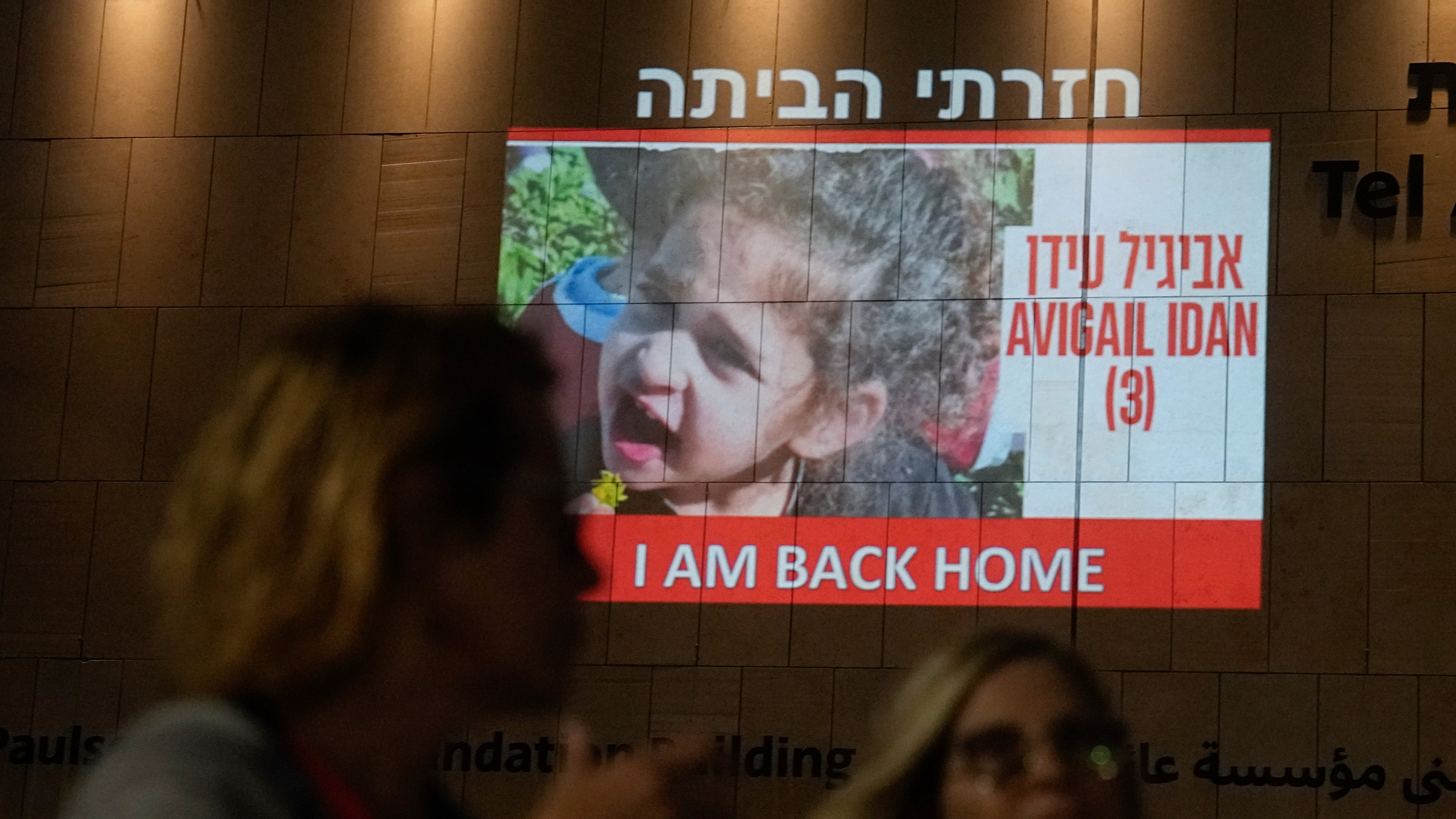 La gente pasa junto a una imagen de Abigail Edan, de 4 años, una rehén retenida por Hamás que fue liberada el domingo, proyectada en un edificio en Tel Aviv, el domingo 26 de noviembre de 2023. Los padres de Edan fueron asesinados por militantes de Hamás en el El mismo ataque en el que fue secuestrada, un asalto transfronterizo el 7 de octubre que llevó a Israel a declarar la guerra a Hamás. (Foto AP/Ariel Schalit)