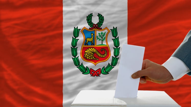 man voting on elections in peru front of flag