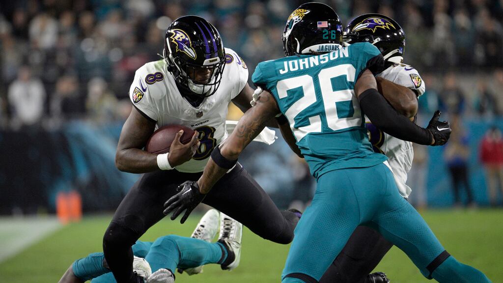 El quarterback de los Ravens de Baltimore Lamar Jackson intenta avanzar con el balón frente al safety de los Jaguars de Jacksonville en el encuentro del domingo 17 de diciembre del 2023. (AP Foto/Phelan M. Ebenhack)