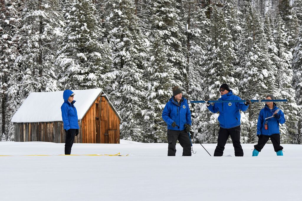 ARCHIVO - En esta foto proporcionada por el Departamento de Recursos Hídricos de California, el jefe de pronósticos, Sean de Guzmán (segundo desde la derecha), e ingenieros trabajan en la fase de medición del primer estudio de nieve para medios de comunicación de la temporada en la Estación Phillips en las montañas de Sierra Nevada, California, el 3 de enero de 2023. (Kenneth James/Departamento de Recursos Hídricos de California vía AP)
