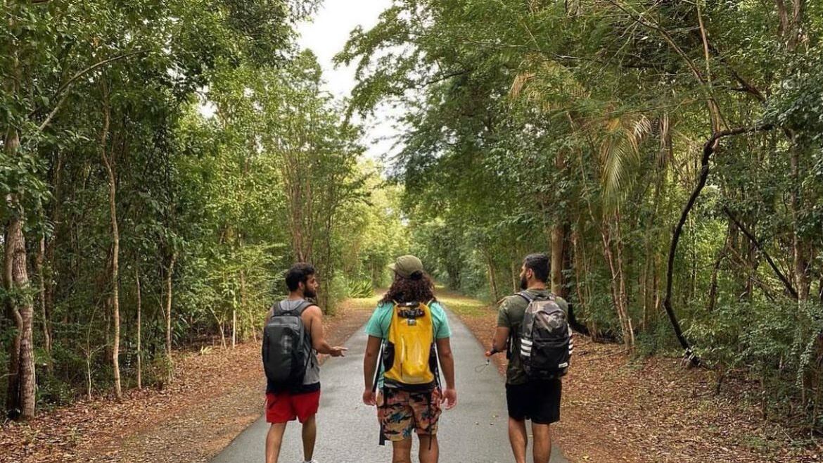 Ricardo Rivera Dávila, al centro, camina por un sendero junto a dos muchachos. Dávila se dedica a planificar recorridos guiados en Puerto Rico, especialmente dirigidos para las personas sordas.